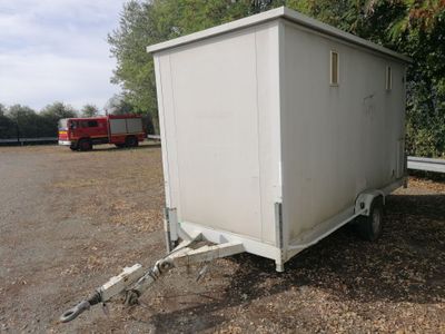 a white trailer that is parked in the dirt