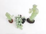 trois figurines représentant un homme et des raisins posées sur une table