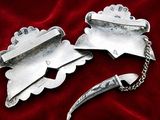 two silver spoons sitting next to each other on a red cloth