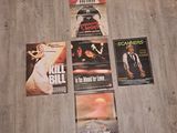 trois affiches de cinéma posées à même le sol d'une pièce au parquet