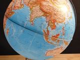un globe terrestre posé sur une table, sur fond noir