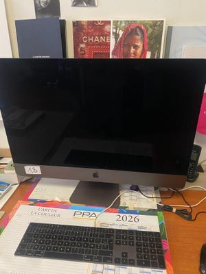 un ordinateur de bureau Apple posé sur un bureau, à côté d'un clavier