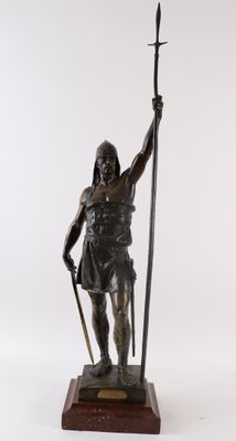 bronze statue of a warrior holding a spear and shield