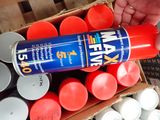 a person holding a can of wax next to a box of candles