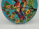 two birds on a branch of a tree with flowers on a blue plate