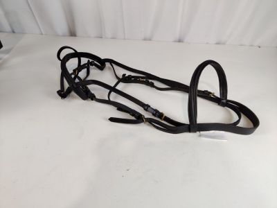 un gros plan sur une paire de brides noires posées sur une surface blanche