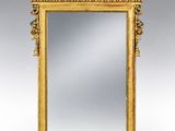un miroir ancien dans un cadre doré, orné d'un motif représentant un oiseau et des fleurs