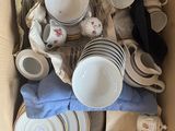 une boîte en carton remplie d'une multitude d'assiettes et de tasses