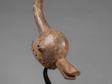 a wooden sculpture of a bird on a black stand