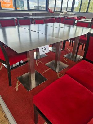 a table and chairs in a room with a lot of windows