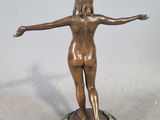 statue of a woman standing on a marble base with her arms outstretched