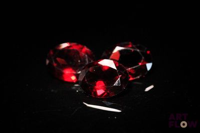 deux losanges rouges sur une surface noire, sur fond noir