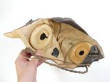 une personne tenant un sac en papier orné d'un masque d'animal