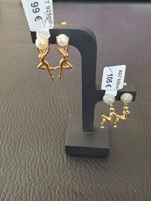 une paire de boucles d'oreilles posée sur un présentoir, avec une étiquette de prix