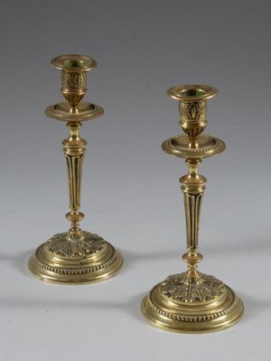 pair of antique brass candlesticks on a white background