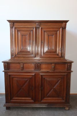 a wooden cabinet with two doors on top of it