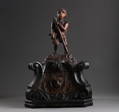une figurine en bronze représentant un garçon assis sur un banc