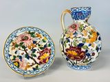 deux vases et une assiette décorés de fleurs, posés les uns à côté des autres
