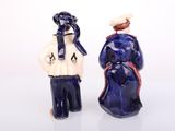 two figurines of a man and a woman standing next to each other