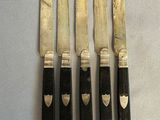 five knives with black handles on a white surface