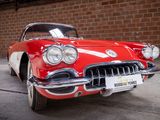 a red and white car parked in front of a brick wall
