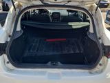 the back of a white car with its trunk open in a parking lot