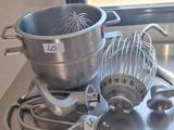 a metal table with a mixer, a bowl, and a whisk on it