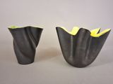 two black vases with yellow flowers in them