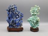 une paire de vases bleus et verts posés sur un socle en bois, sur fond gris