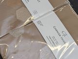 three sheets of brown paper wrapped in plastic on a table