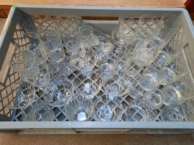many empty glasses in a plastic container on the floor