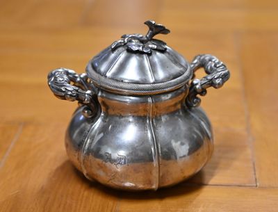 une casserole en argent posée sur une table en bois