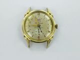a gold watch on a white surface with a white background