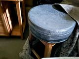 a blue stool sitting in the middle of a pile of furniture