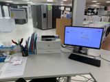 a desk with a computer and a printer on it