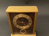 an image of a gold clock with roman numerals on the face
