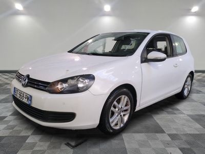 la volkswagen golf blanche est garée sur un carrelage à carreaux