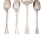 four spoons and a spoon rest on a white surface