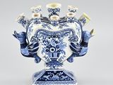 un vase bleu et blanc dans lequel se trouve un bouquet de bougies