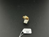 a white and gold ring sitting on top of a black table