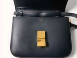 the small black bag has a gold buckle on the front