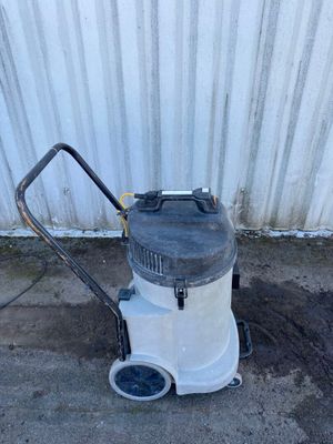 un aspirateur blanc et noir posé par terre à côté d'un immeuble