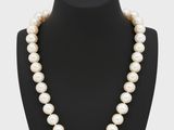 un collier de perles blanches sur un mannequin noir