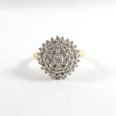 une image d'un anneau en forme de grappe de diamants sur un fond blanc