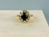 une bague en diamant noir et blanc posée sur un bloc de marbre