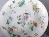 pair of porcelain plates with flowers and birds on them on a table