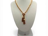 necklace with gold chain and tassel on mannequin base