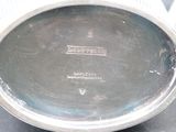 a silver plate on a table with a black background