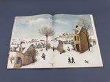 an open book with a picture of a village in the snow