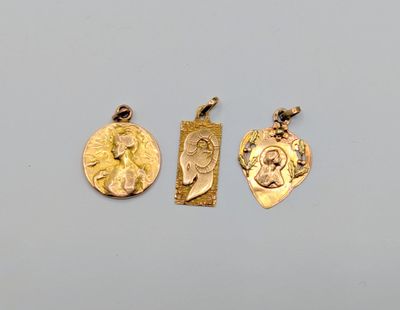 trois pendentifs en or sur lesquels figurent les portraits d'une femme et d'un homme